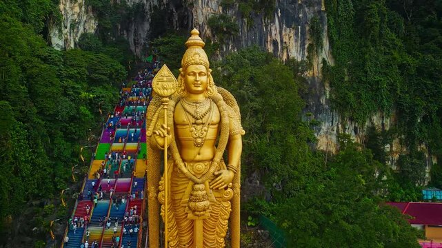 A Majestic Golden Statue of Lord Murugan at Batu Caves in Malaysia With Colorful Steps and Lush Greenery Surrounding the Area
