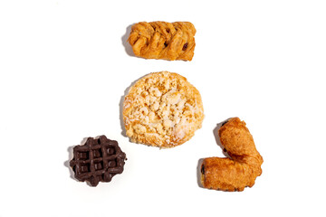 Three different types of pastries are displayed on a white background. The pastries are a waffle, a cookie, and a doughnut Sweet pastries isolated on white background.