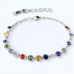 Obraz premium A silver bracelet adorned with colorful gemstones, showcasing a vibrant design.