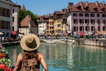 Fototapeta premium Traveling woman in alpine village with flowers and colorful houses. Annecy. France