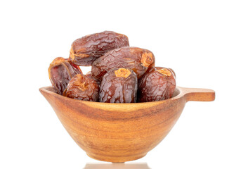 Dried sweet dates in a wooden cup, isolated on a white background, close-up.