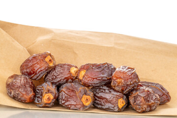 Dried sweet dates with paper bag, isolated on white background, close-up.