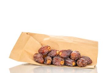 Dried sweet dates with paper bag, isolated on white background, close-up.