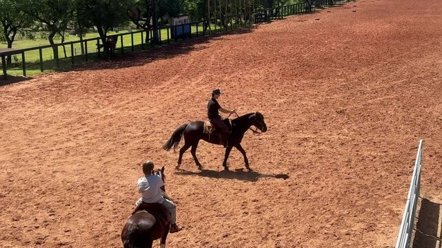 pai e filho andando de cavalos em arena 