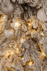 A Christmas tree sprinkled with artificial snow in the New Year's interior. Background for New Year wallpapers and postcards.