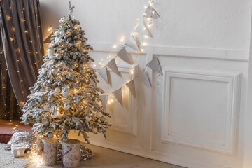 A Christmas tree sprinkled with artificial snow and a tent decorated with a luminous garland in the New Year's interior. Background for New Year wallpapers and postcards.