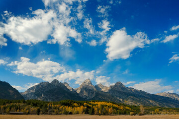 Fototapeta premium Grand Teton Mountains Tetons in Wyoming Rugged Mountain Range in Autumn Fall Landscape with blue sky and clouds