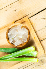 aloe vera and pieces of its pulp on a wooden pit