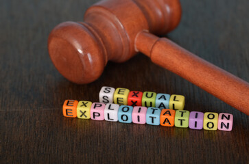 Alphabet Beads Forming 'Sexual Exploitation' with a Judge Gavel - Symbolizing Justice and Awareness...