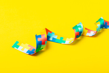 Autism ribbon. Autism awareness day. World autism awareness day with puzzle pattern ribbon on textured background. Colorful puzzle ribbon. Medicine concept. Space for text. Copy space