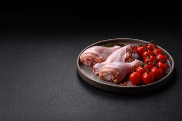 Raw chicken legs with salt, spices, herbs and tomatoes
