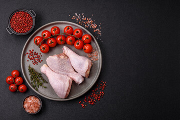 Raw chicken legs with salt, spices, herbs and tomatoes