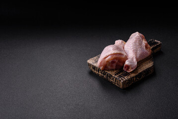 Raw chicken legs with salt, spices, herbs and tomatoes