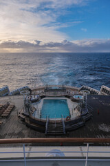 Breathtaking sunset sunrise ocean view from outdoor teak pool promenade deck of ocean liner at sea during transatlantic crossing to New York