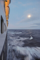 Breathtaking sunset sunrise ocean view from outdoor teak pool promenade deck of ocean liner at sea...