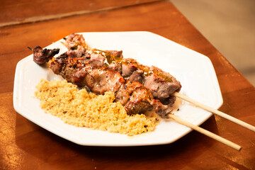lamb skewer and barbecue beef filet mignon on a plate with farofa