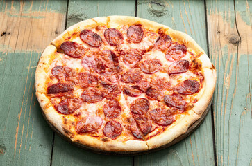 Pizza pepperoni fast food . Top view on rustic background