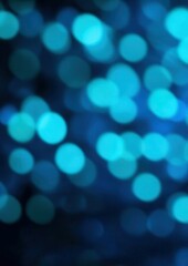 Naklejka premium An abstract image featuring a bokeh effect with numerous out of focus blue and teal circles on a dark background