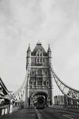 A stunning black and white shot of the Tower Bridge in London with a bus crossing beneath its...