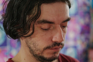 Fototapeta premium Man with tousled hair gazes thoughtfully into the distance amidst a lively atmosphere