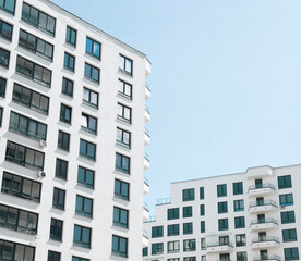 Modern urban building in a cityscape. Tall condominium facade and clean architectural design. Commercial high-rise tower in a financial center. Perspective view of a new property.