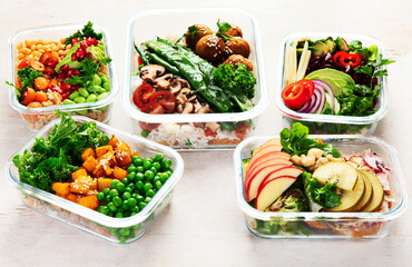 Glass containers with fresh vegan food, ready for meal prepping.