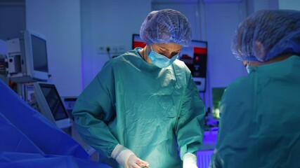 Female surgeon uses a thread and needle to sew the patient. Final stage of a surgical operation on a hand.