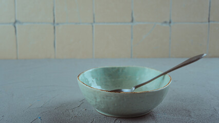 Empty ceramic bowl with metal spoon