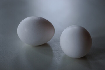 close-up of two white eggs isolated on plain surface with space for copy metaphor twins cooking life health farm fresh nutrition