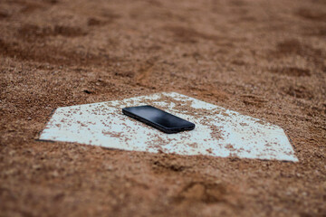 baseball sports home plate with smartphone phone technology and balance outdoor activity social issue background