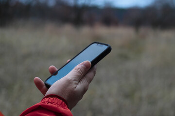 mobile phone in a hand outdoor nature technology communication background