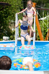 Naklejka premium Two sisters in bikini near swimming pool. Hot Summer