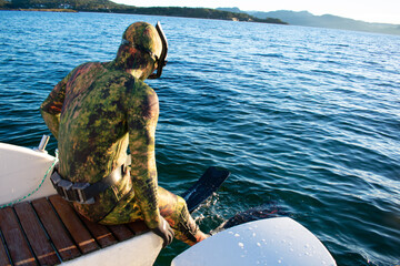 Diver in Scuba wetsuit jumping off a boat to Snorkel – Norway Vacations