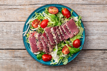 Salad with raw tuna , sesame and cherry tomatoes photography . Top view