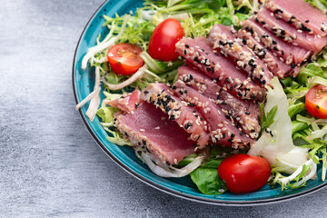 Salad with raw tuna , sesame and cherry tomatoes photography . Top view