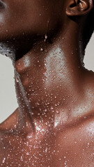 Fototapeta premium An advertising photo. Close-up of a dark-skinned woman's neck with water droplets. Advertising of a care product.