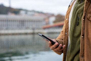 Tourist using smartphone saone river in Lyon, France