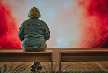 Mujer senior contempla una pantalla grande