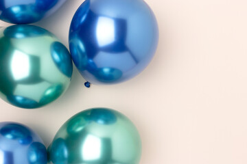 Multicolored inflatable balloons on a beige background. Festive composition with place for text. Selective focus.