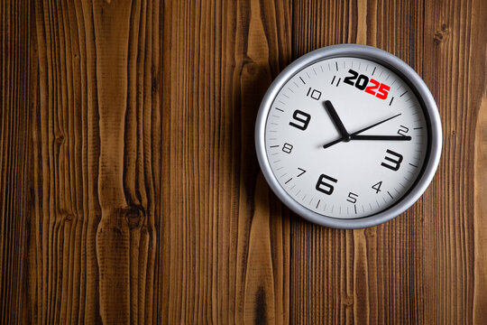 large white clock face with digits on a wooden background top view