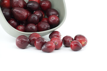 Fresh Cranberries Spilling from Gray Bowl on White Background