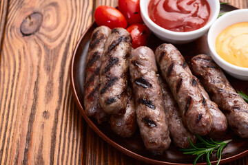 Grilled beef sausages with rosemary sauce and tomatoes photography . Top view