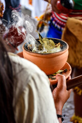 Aromatic herbs burning in a clay pot in a traditional Umbanda smoking ceremony in Brazil