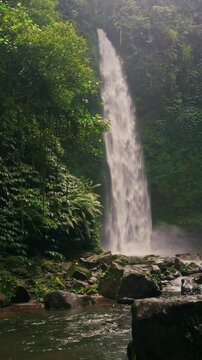 Bali waterfall Air Terjun Nungnung breathtaking 50-meter waterfall Bali's lush highlands. One of the most popular travel destinations Bali, Indonesia 4K vertical video