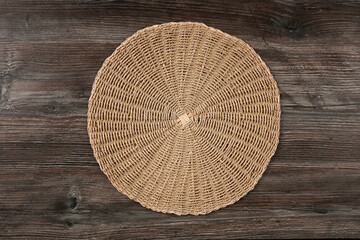 Top view beautiful round rug woven from jute lies on a wooden table.