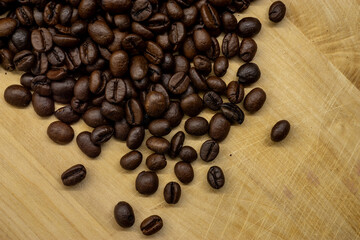 Roasted coffee beans scattered on wooden cutting board