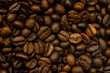 Roasted coffee beans forming a textured background for cafe and coffee lovers