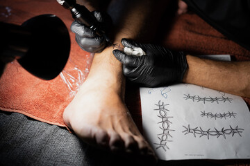 Tattoo artist tattooing a man's leg