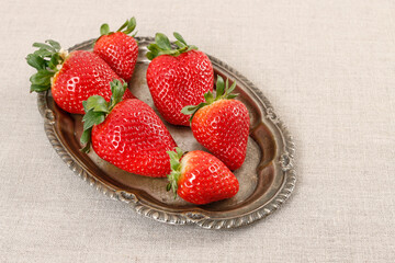 Bowl with strawberries on white wooden table.