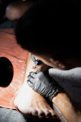 Tattoo artist tattooing a man's leg